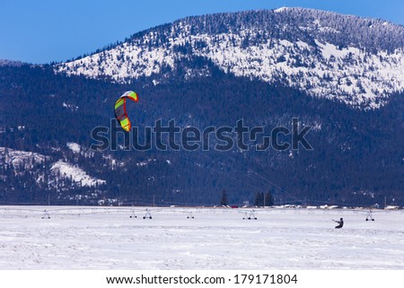 RATHDRUM, IDAHO USA - FEBRUARY 25, 2014. An unknown thrill seeker takes advantage of a nice day and the wind to go kite boarding on the snow on February 25, 2014.