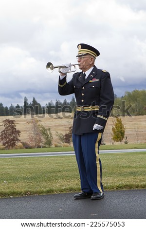 MEDICAL LAKE, WA. USA - OCTOBER 15, 2014. A man plays taps on his bugle at a veterans funeral at Medical Lake Veterans Memorial in Washington.