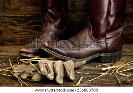 Cowboy boots on top of leather gloves.