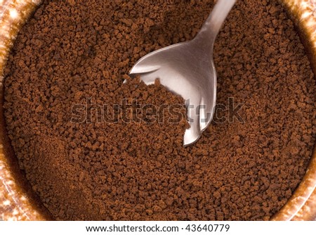 Looking down at dry coffee grounds and a spoon.