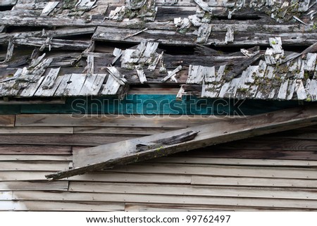 The run down, broken up roof of an abandoned old house.