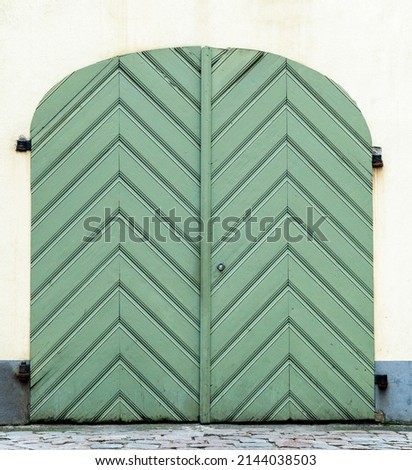 Image, Stock Photo large wooden gate with plain door handle, slanted wooden boards and painted with different green paint, which is peeling off