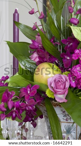 Elegant floral bouquet of lavender orchids, roses and a golden delicious apple