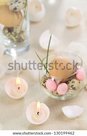 Easter eggs-candles with over eggs in glass background