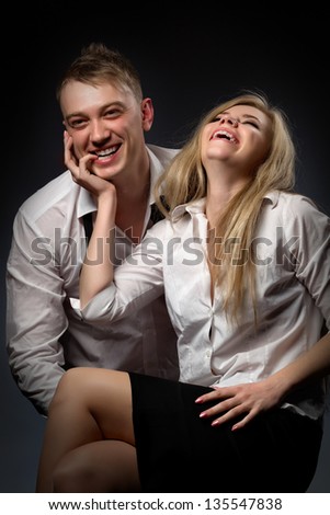 Photo of a couple in white shirt and black tie, the man holding sexy woman.