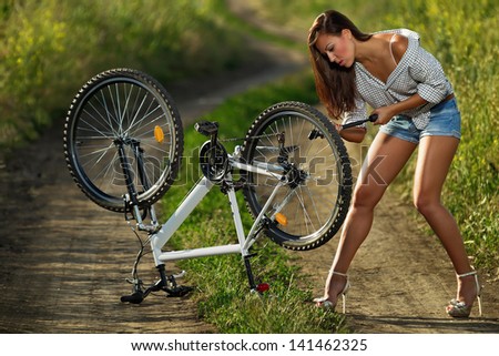 Bicycle has flat tyre and woman pump it up