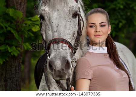 portrait of a pretty young woman with a white horse (Focus on horse)