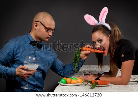Lovely man in rabbit costume is feeding his girlfriend bunny