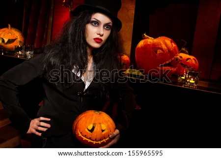 Halloween concept: sexy lady vampire next to bar over red background