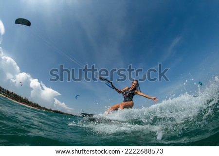 Similar – Image, Stock Photo Female kite surfer riding on board in sea