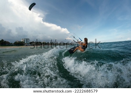 Similar – Image, Stock Photo Female kite surfer riding on board in sea