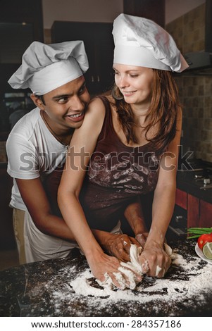 Attractive Mixed Race Young couple cooking dinner