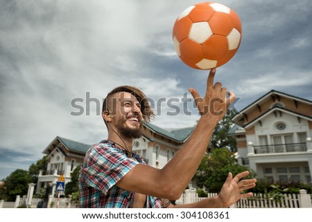 Attractive man spinning a ball on his finger on the street
