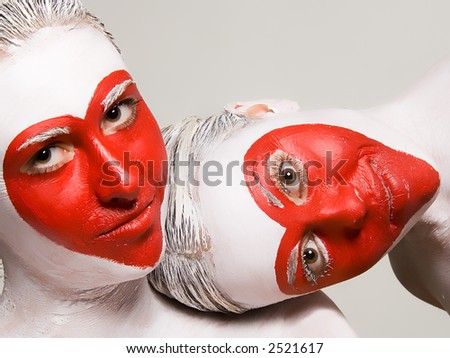 Two girls with painted faces delivering red heart pattern