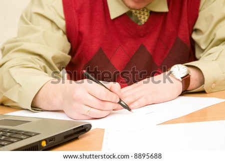 Businessman in formal wear writing down a notes at work place