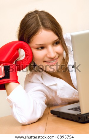 Attractive young woman at work place with boxing gloves ready to defence