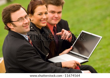 Business team with laptop at outdoor meeting