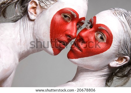 Two pretty girls with faces painted red heart shapes
