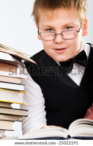 smart looking school boy reading a book, isolated on white
