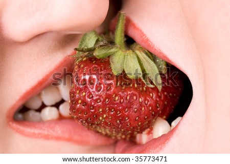 Female lovers enjoying erotic act with fresh strawberry