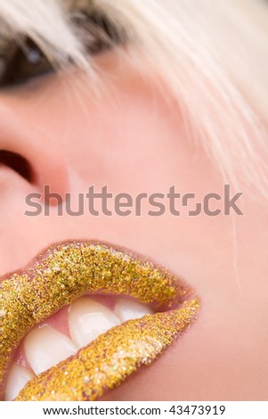 Female model face with glossy golden lips closeup
