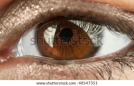 The reflection of the photographer with a camera pupil of brown eye