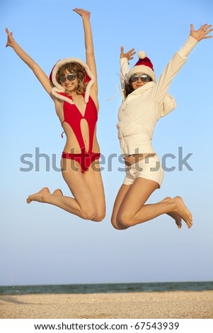 Happy girls in Santa Clause suit having fun on the beach
