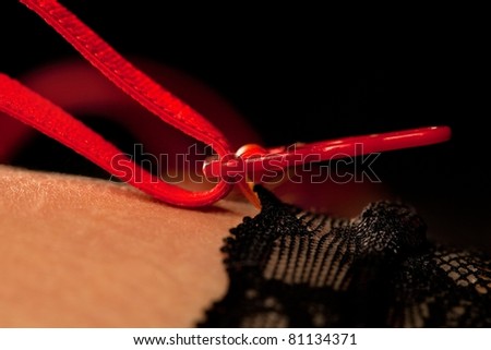 Beautiful woman\'s thigh in black stockings with red suspenders, close-up