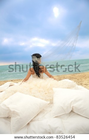 Rear view of young bride in bed at the coastline.