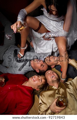 Crazy wedding party in night club. bride making a drunkard of friends of groom