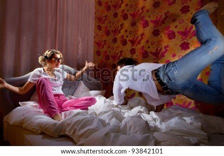 Happy boyfriend flying on bed to his sweetheart at home