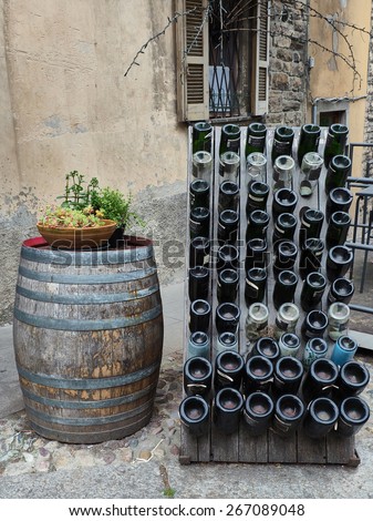 Old handmade Wine barrel and bottle outside a bar in Italy