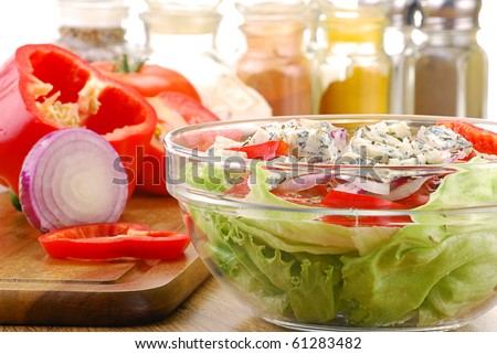 Vegetable salad bowl and salad ingredients on breadboard