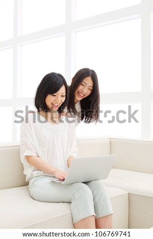 two beautiful asian women using laptop computer