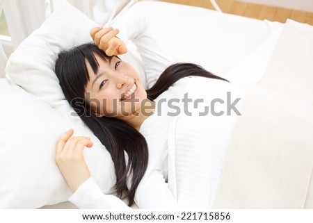 Beautiful young woman relaxing in the bedroom. Portrait of asian woman