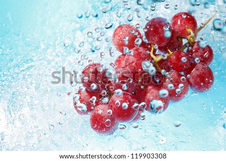 water splashing on a bunch of red grapes