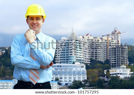 Young architect wearing a protective helmet standing on the mountains building outdoor background