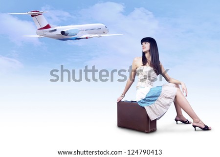 Young woman on the vintage baggage wait on the flying