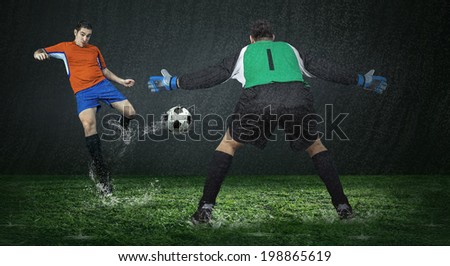 Two football players in action under rain in stadium