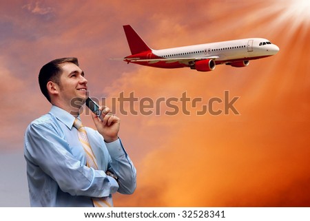 man looks at airplane in air with sunrise sky
