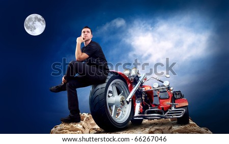 Men with motorbike on the top of mountains in night and moon.