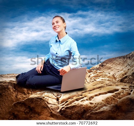 Happy Businesswoman seating with laptop on the mountain under blue sky