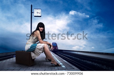 Girl waiting train on the platform of railway station