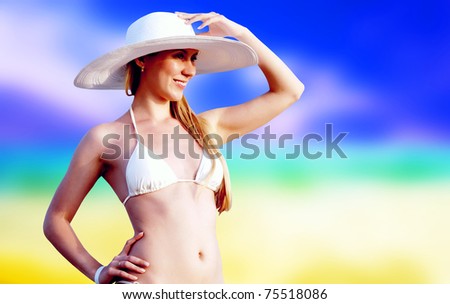 Young beautiful women on the sunny tropical beach in bikini and white hat