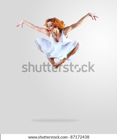 Woman dancer jump posing on background