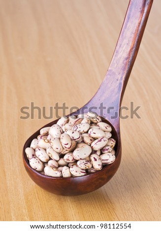 pinto beans on wooden spoon