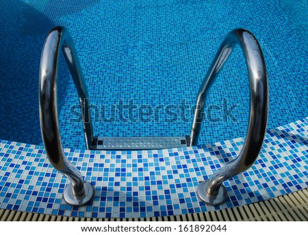 Grab bars ladder in blue swimming pool