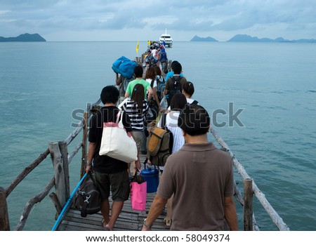 People going to boat on wooden pier at the sea side