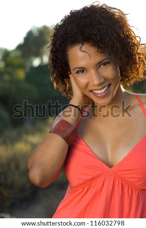 Smiling young beauty - Happy African American beauty with natural hair style in a field of tall grass, backlit by the sun