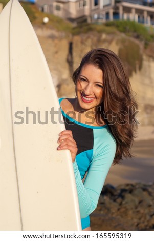 Smiling surfer girl - Closeup of beautiful young surfer girl holding her surfboard.
